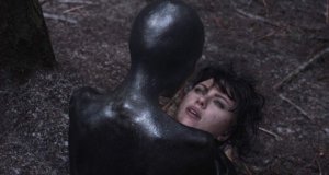 A black figure stares at a woman's face