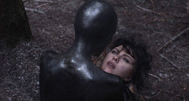 A black figure stares at a woman's face