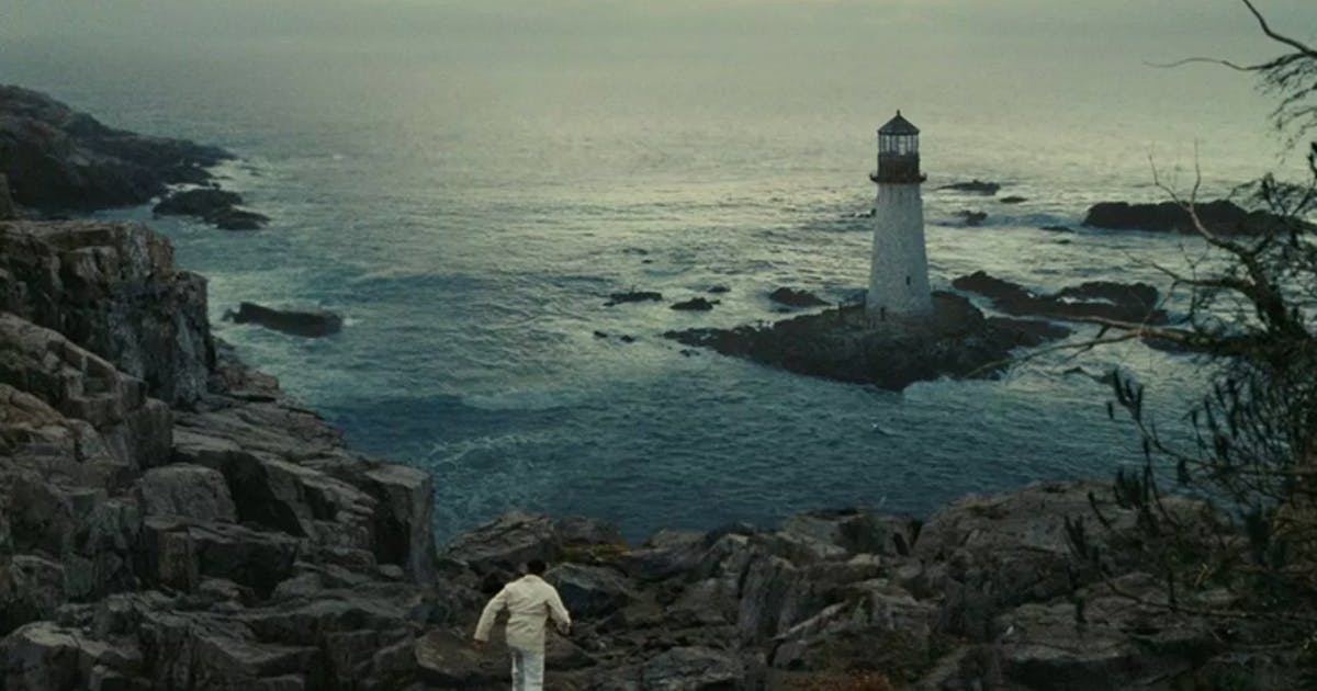 Teddy walks towards a lighthouse on the coast of a sea