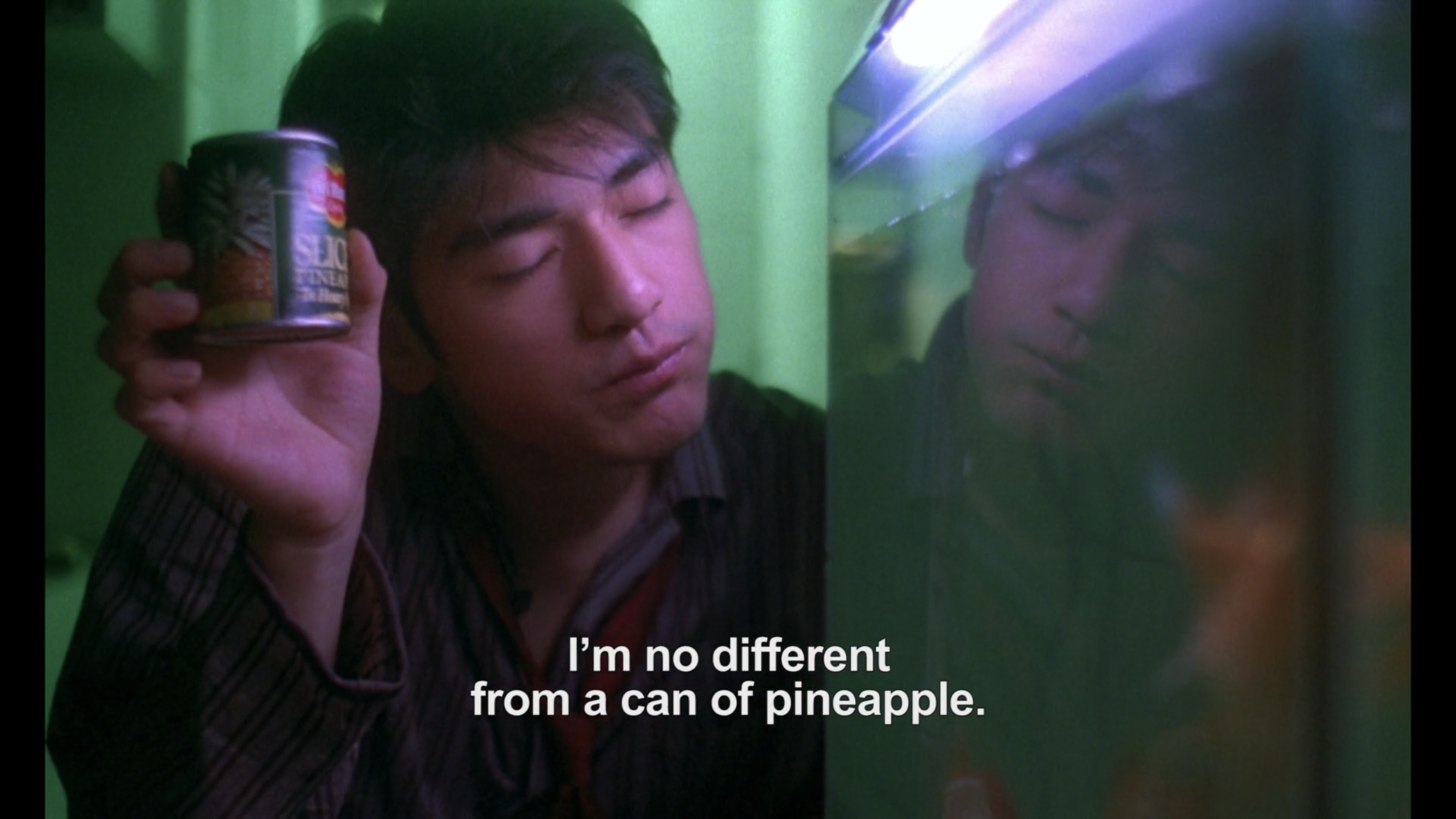 He Qiwu holds up a can of pineapple next to his fish tank in Chungking Express