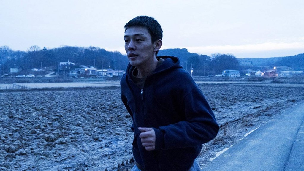 Lee Jong-su (Yoo Ah-in) jogs on the South Korean countryside in Burning (2018)