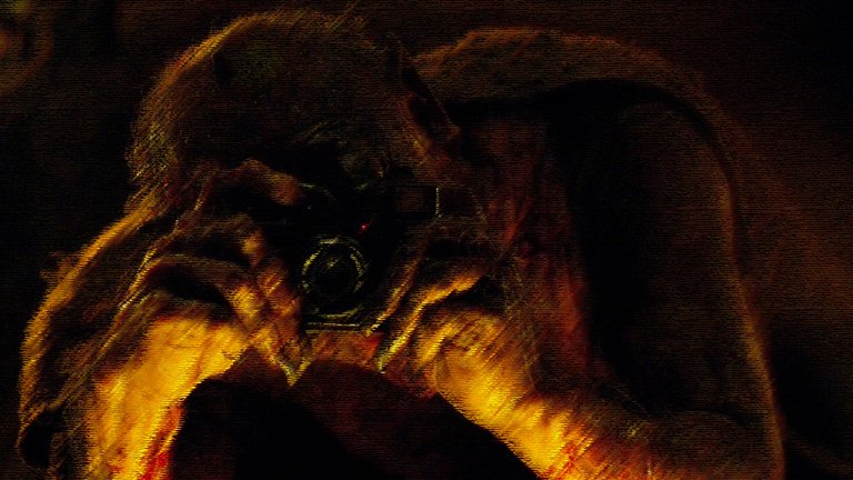 The Stranger turns into the Devil and uses his camera to take a picture of the deacon in The Wailing