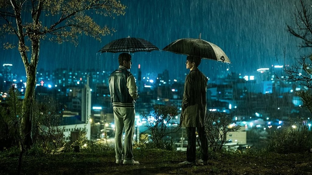 Two brothers, Jin-seok and Yoo-seok, stand in the rain holding umbrellas in Forgotten (2017)