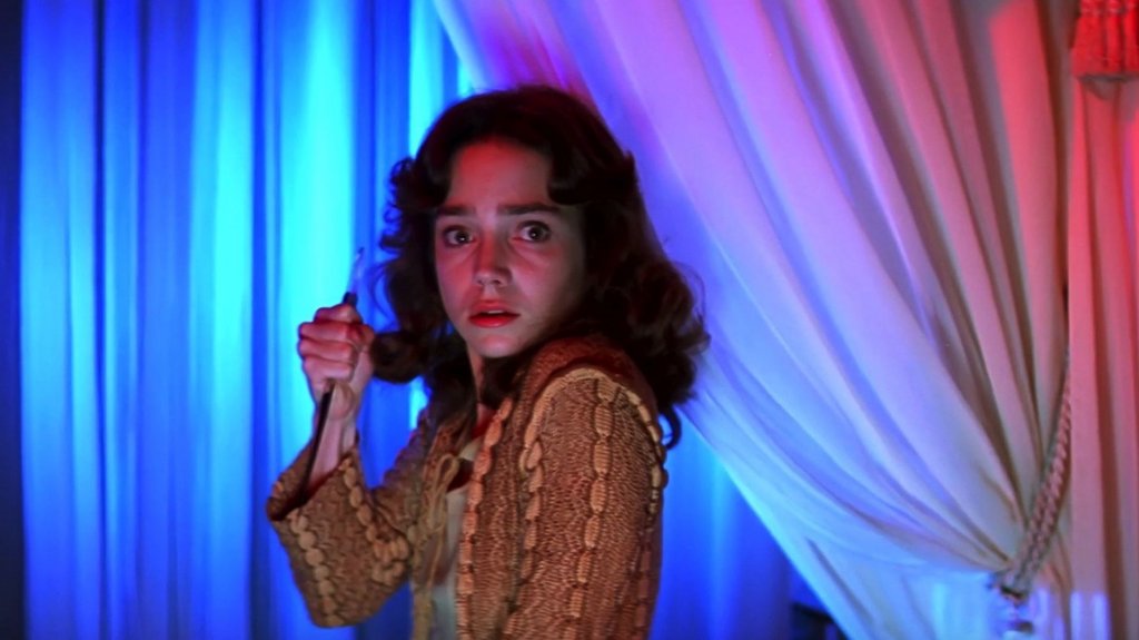 Suzy (Jessica Harper) stands in terror and holds a knife in Suspiria (1977)