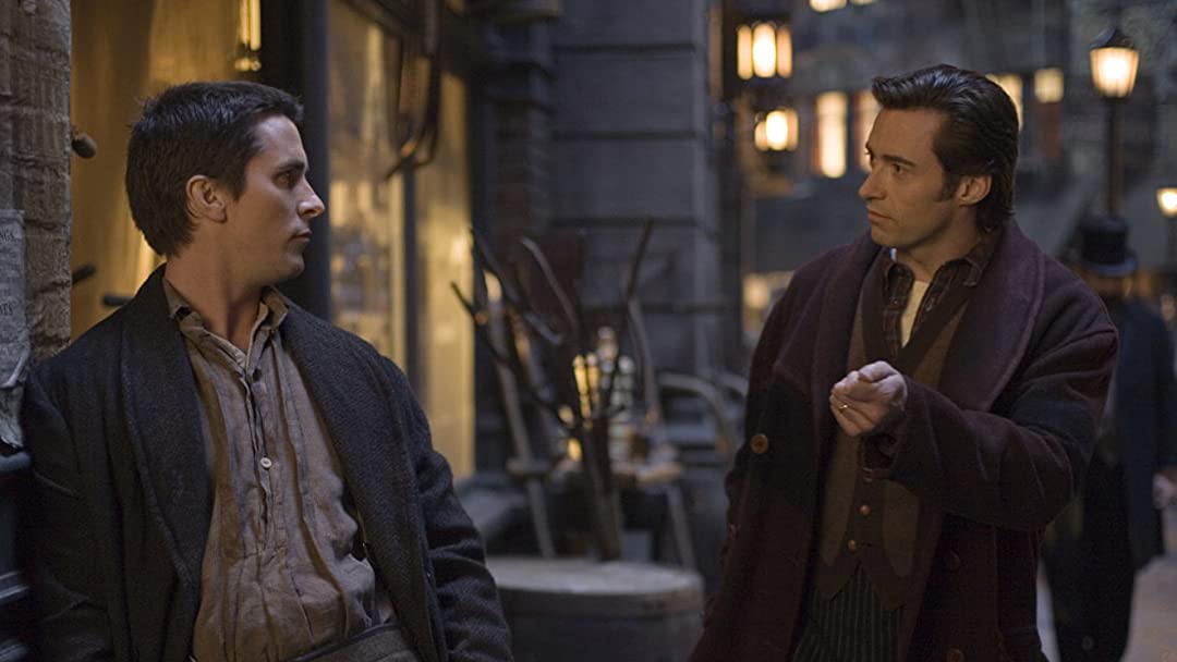 Alfred Borden (Christian Bale) and Robert Angier (Hugh Jackman) talk to each other in The Prestige