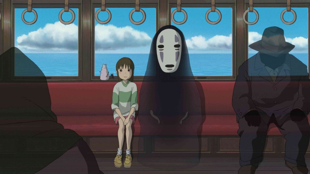 Chihiro sits on a monorail train with Kaonashi in Spirited Away