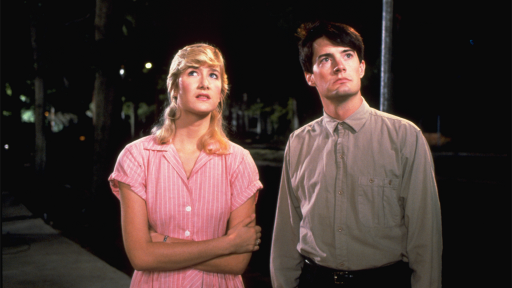 Jeffrey and Sandy look up while standing in the street in Blue Velvet