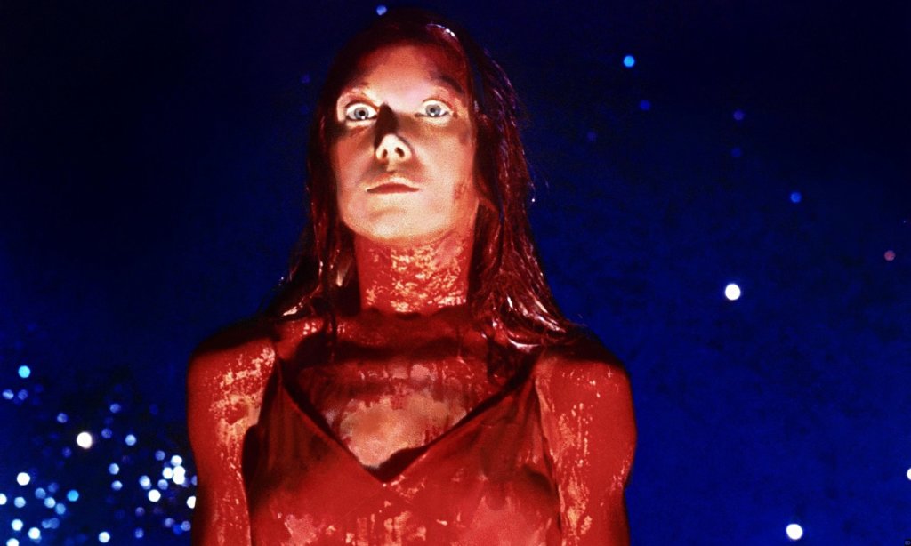 Carrie stands on stage at her high school prom covered in blood