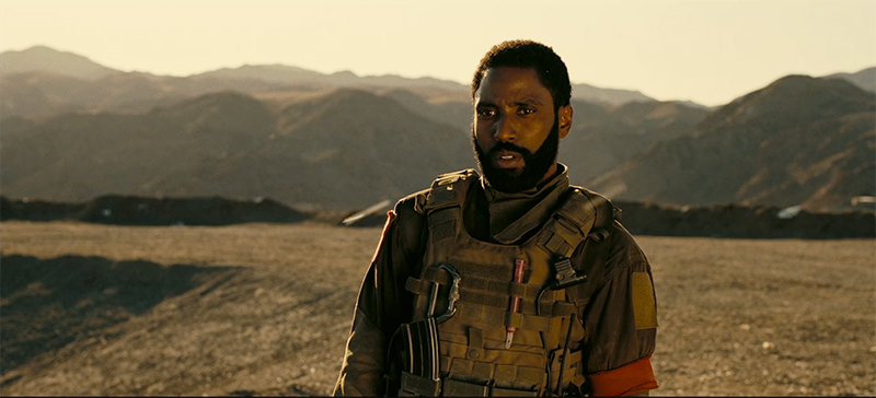 The Protagonist (John David Washington) wears body armor in a desert in Tenet