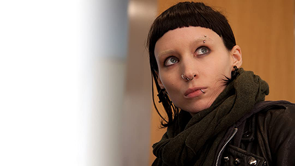 A girl with black hair in a black coat looks up and to her left