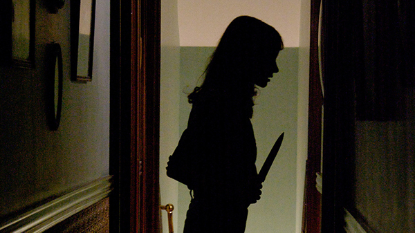 The silhouette of a woman holding a knife