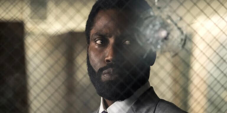 The protagonist looks through a glass window with a bullet hole in it