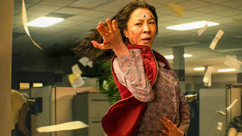 A woman performs kung fu in an office as papers fly around