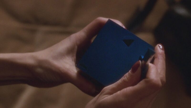 A woman's hands hold a blue box and a blue key