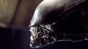 An black alien bares its sharp teeth