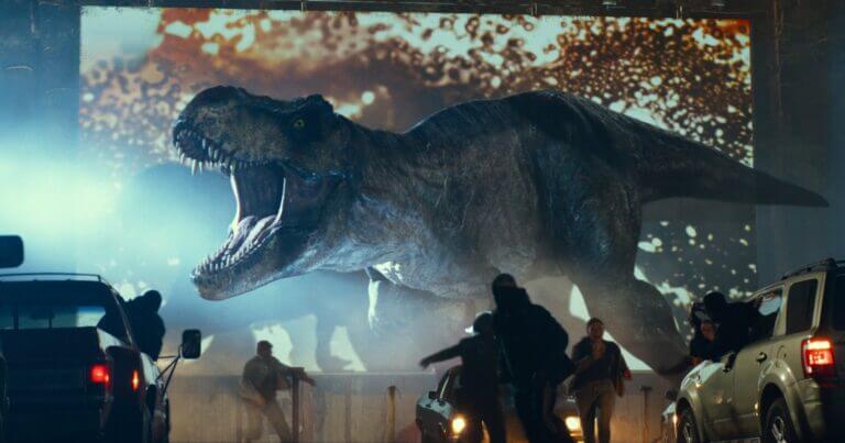 A dinosaur stomps through a drive-in movie theater in Jurassic World: Dominion