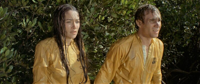 A man and a woman dressed in wet yellow jumpsuits