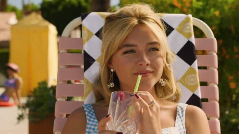 Alice, dressed in a blue and white plaid dress, sits in a pink lawn chair and drinks from a cup through a straw