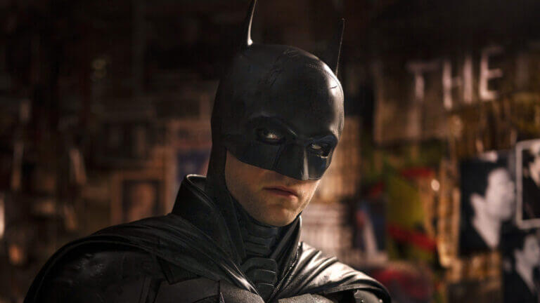 A man in a bat costume (Batman) stars to his right