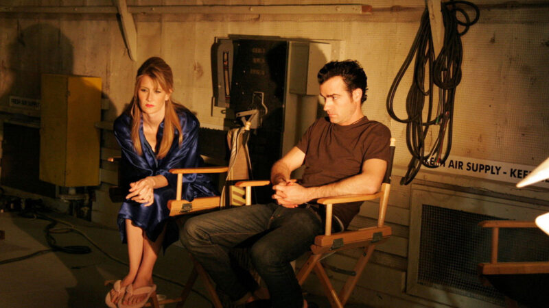 An actress and an actor sit on chairs of a movie set