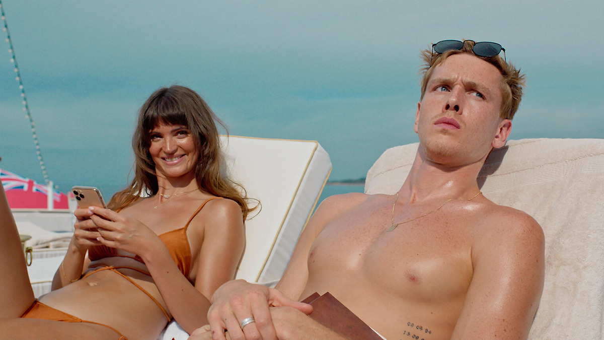 A man and a woman sunbathe on a boat