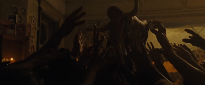A baby is held up by a crowd of people