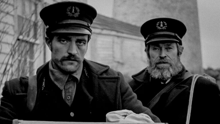 Two men, Wake and Howard, in sailor outfits stare into the camera