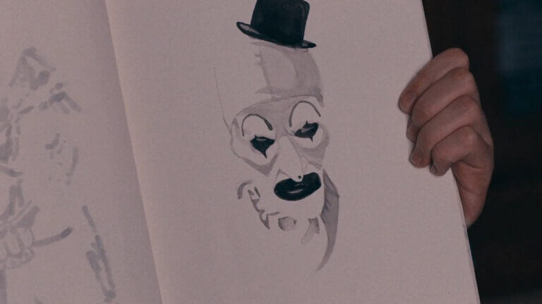A picture of an angry clown's face wearing a small black hat