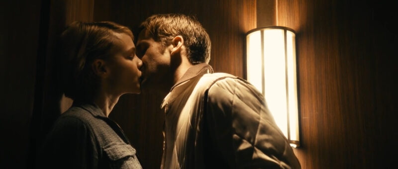 A woman and a man kiss in an elevator