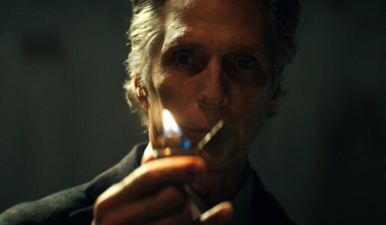 A man holds up a lighter and stares into the flame.
