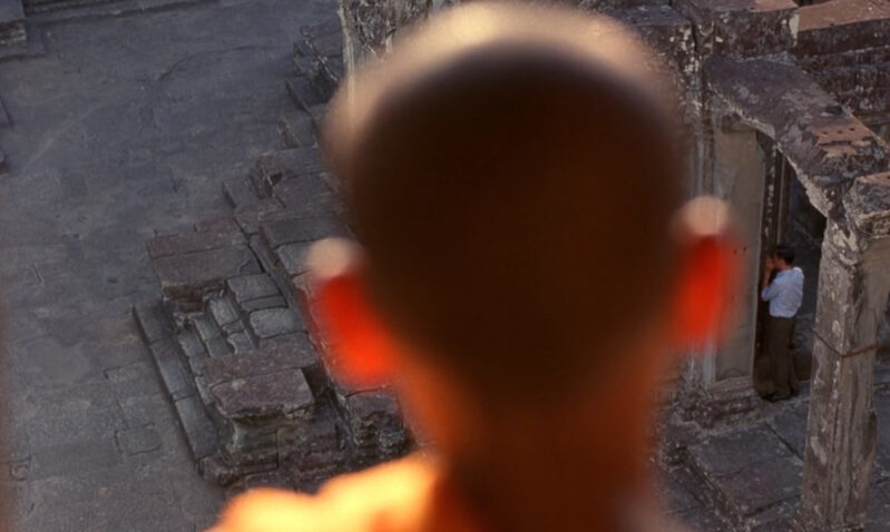 A monk stares at someone from above and afar