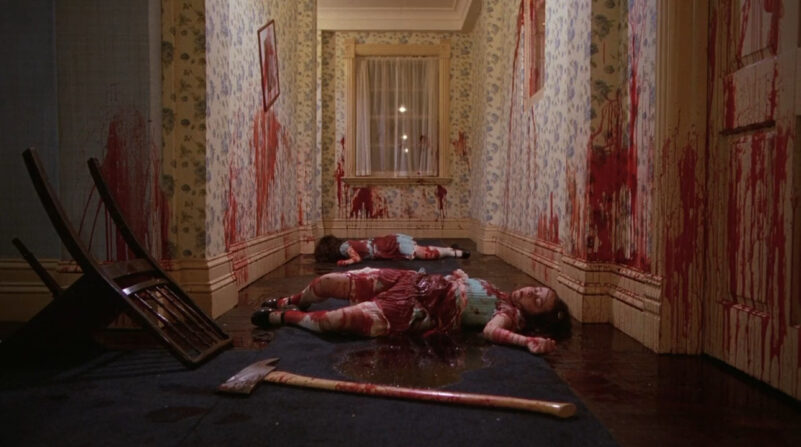 Two girls lie dead in a hallway with blood everywhere and an axe lying in front of them