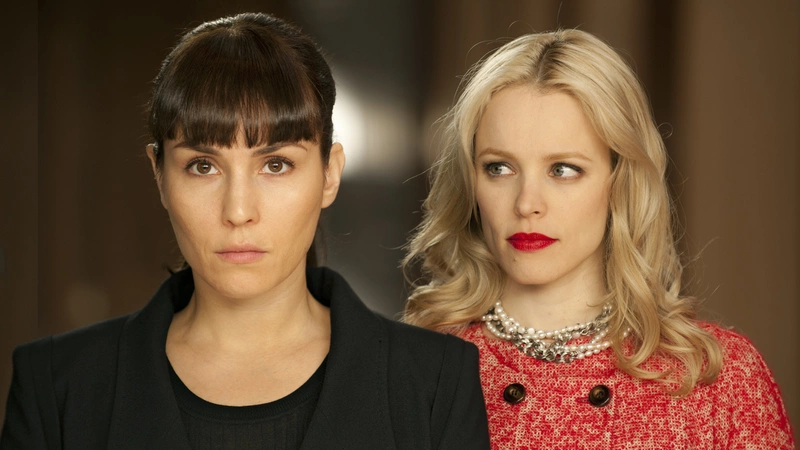 A woman wearing red stares at another woman wearing black