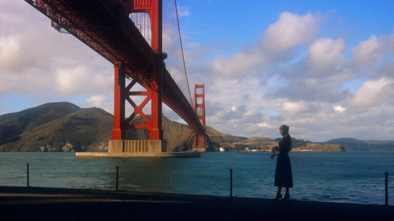 Madeleine stands underneath the Golden Gate Bridge