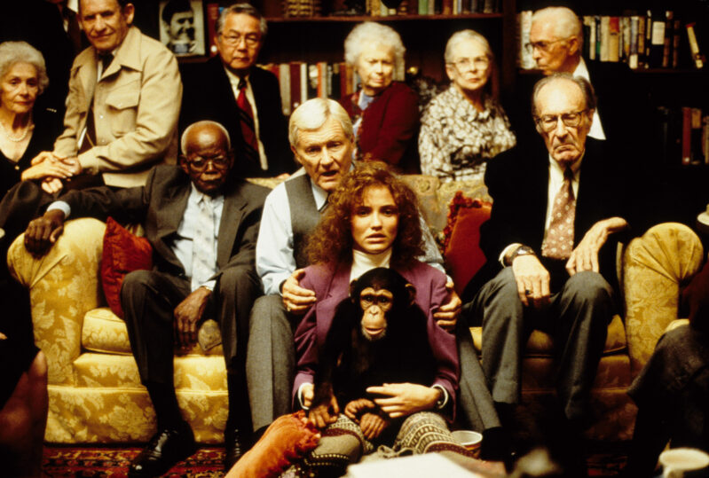 Lotte, Dr. Lester, a chimpanzee, and a group of people waiting to crawl into John Malkovich's mind sit on a couch