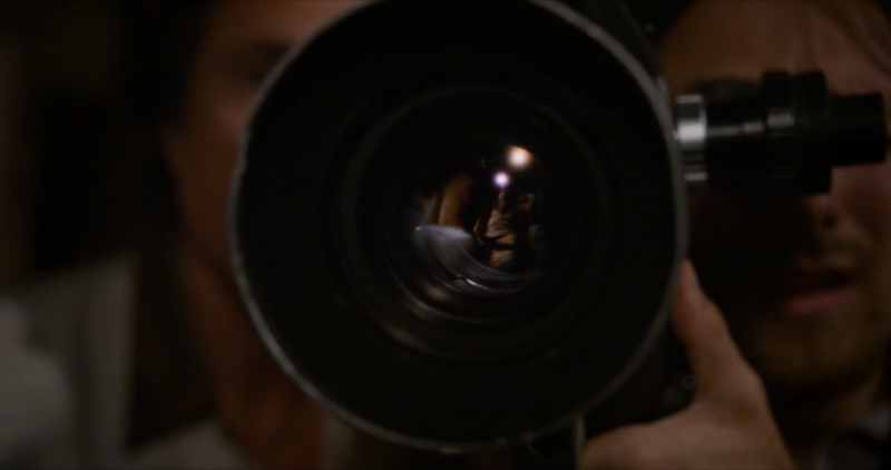 RJ and Wayne look through a camera lens to film a sex scene