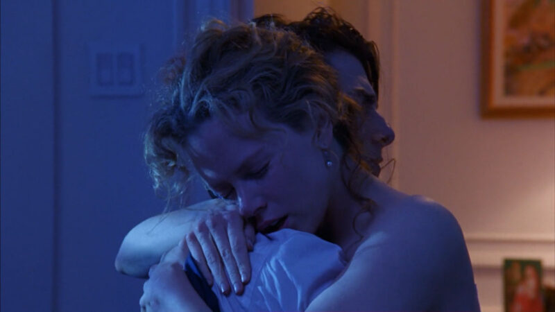 Alice Harford hugs her husband Bill in their bedroom