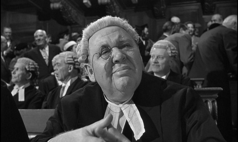 Sir Wilfrid Robarts squints through this monocle in a courtroom