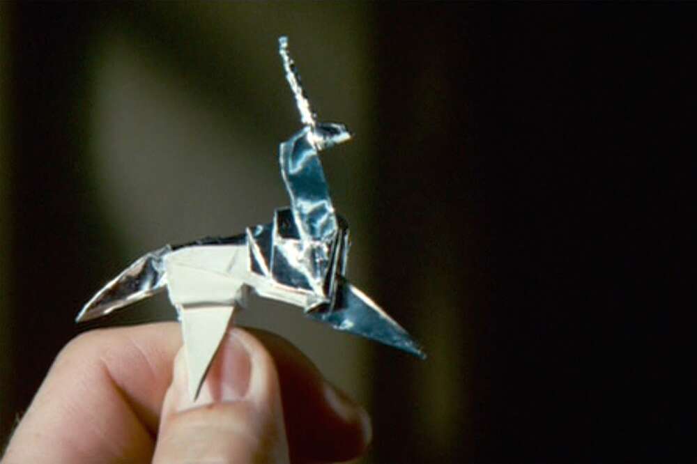 Deckard's hand holds a silver origami unicorn