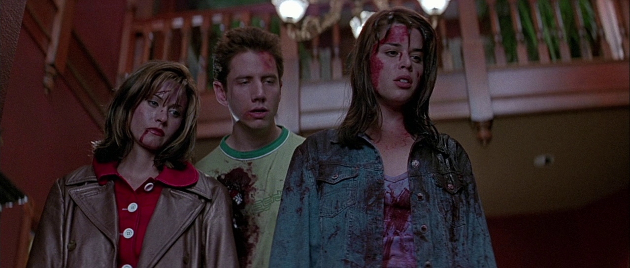 Gale, Randy, and Sidney, covered in blood, look down at Billy's body