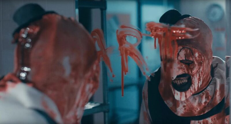 Art the Clown draws his name in blood on a mirror