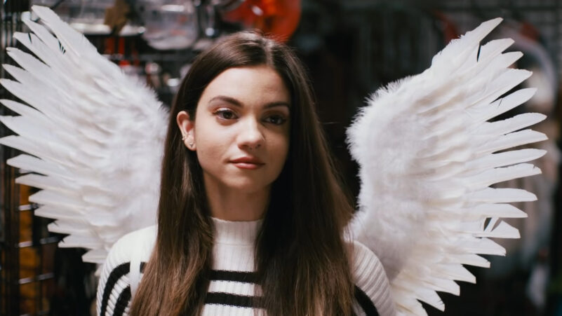 Sienna wears angel wings in a Halloween store