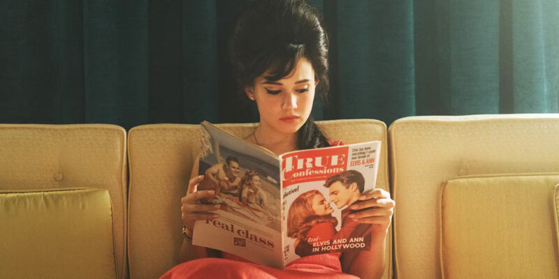 Priscilla Presley reads a magazine while sitting on a couch
