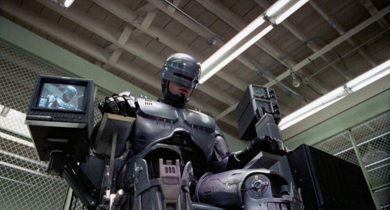 RoboCop sits in a chair 
