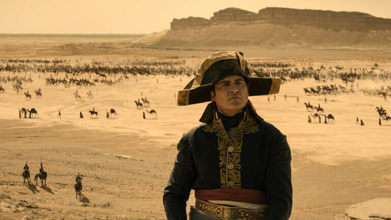 Napoleon Bonaparte looks at something off camera. An army amasses behind him.