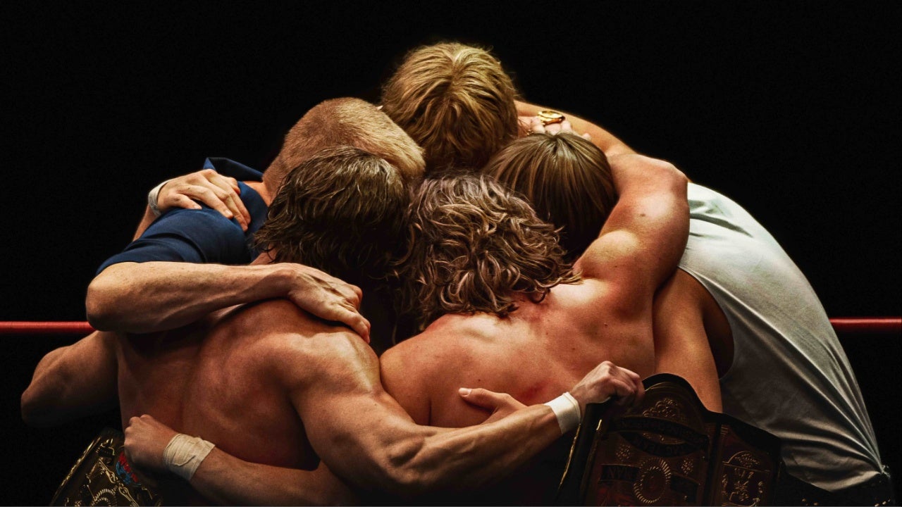 The Von Erich brothers hug their father in the ring after a match.