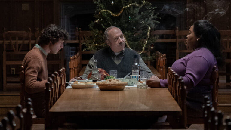 Angus, Hunham, Mary sit to have dinner in front of a Christmas tree