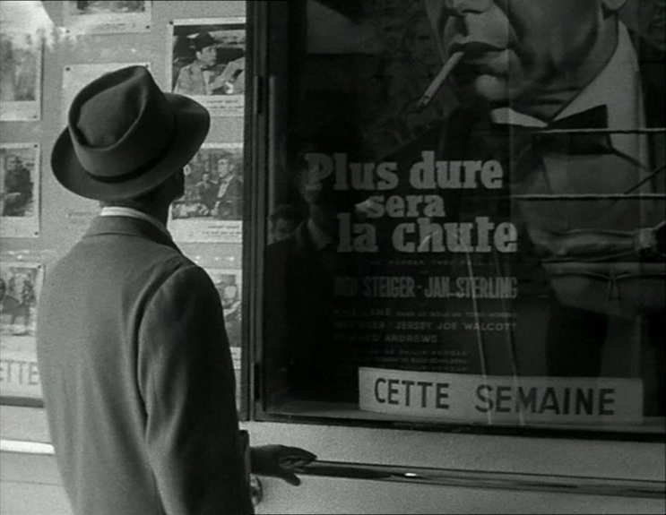 Michel looks at a poster for the film "The Harder They Fall"