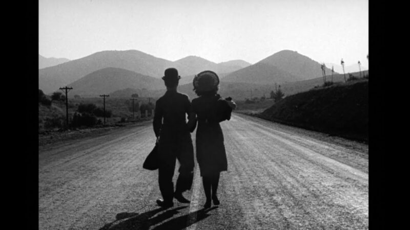 The Tramp and Ellen walk down a road towards the horizon
