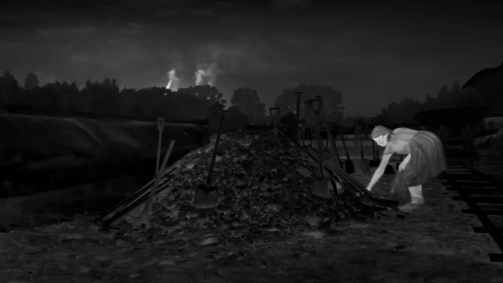 A thermal image of a girl reaching down to pick something out of a pile.